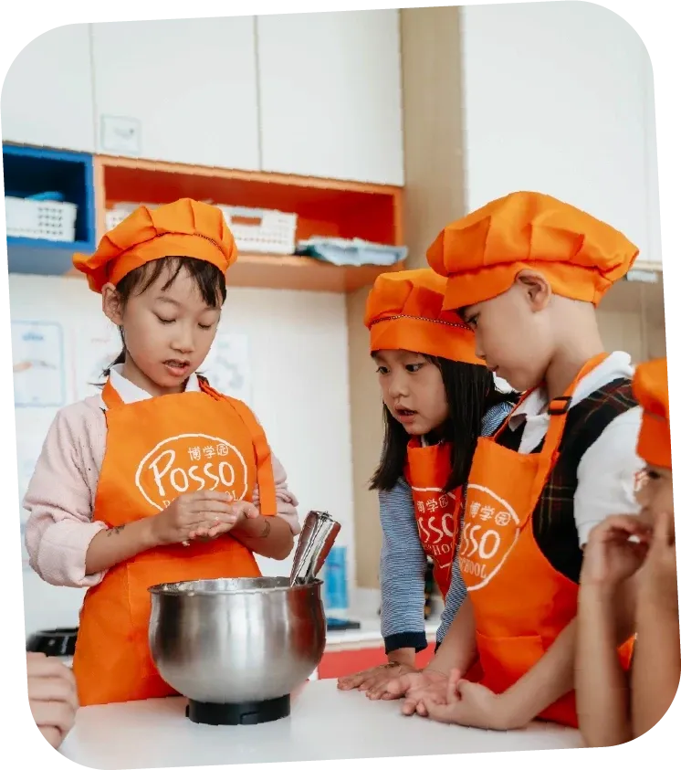 Children cooking in orange Posso aprons