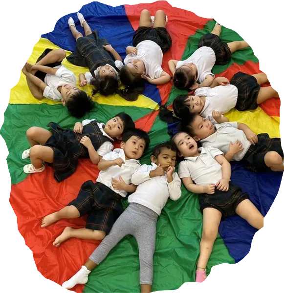 Posso Preschool children lying in a circle on a colourful parachute