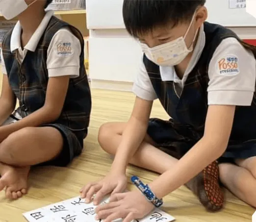 A child tracing Chinese characters on a worksheet