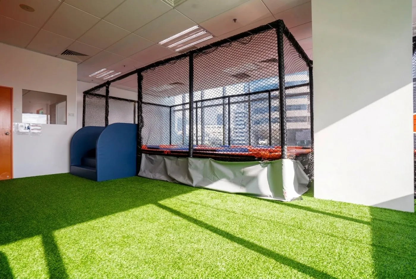The netted indoor trampoline on artificial grass at Posso Jurong East