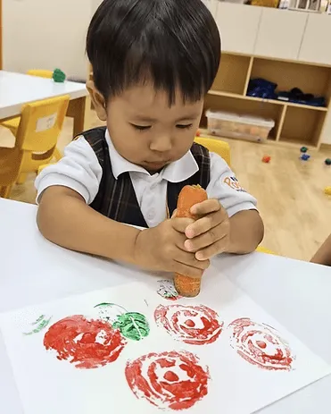 A child stamping apple prints with paint