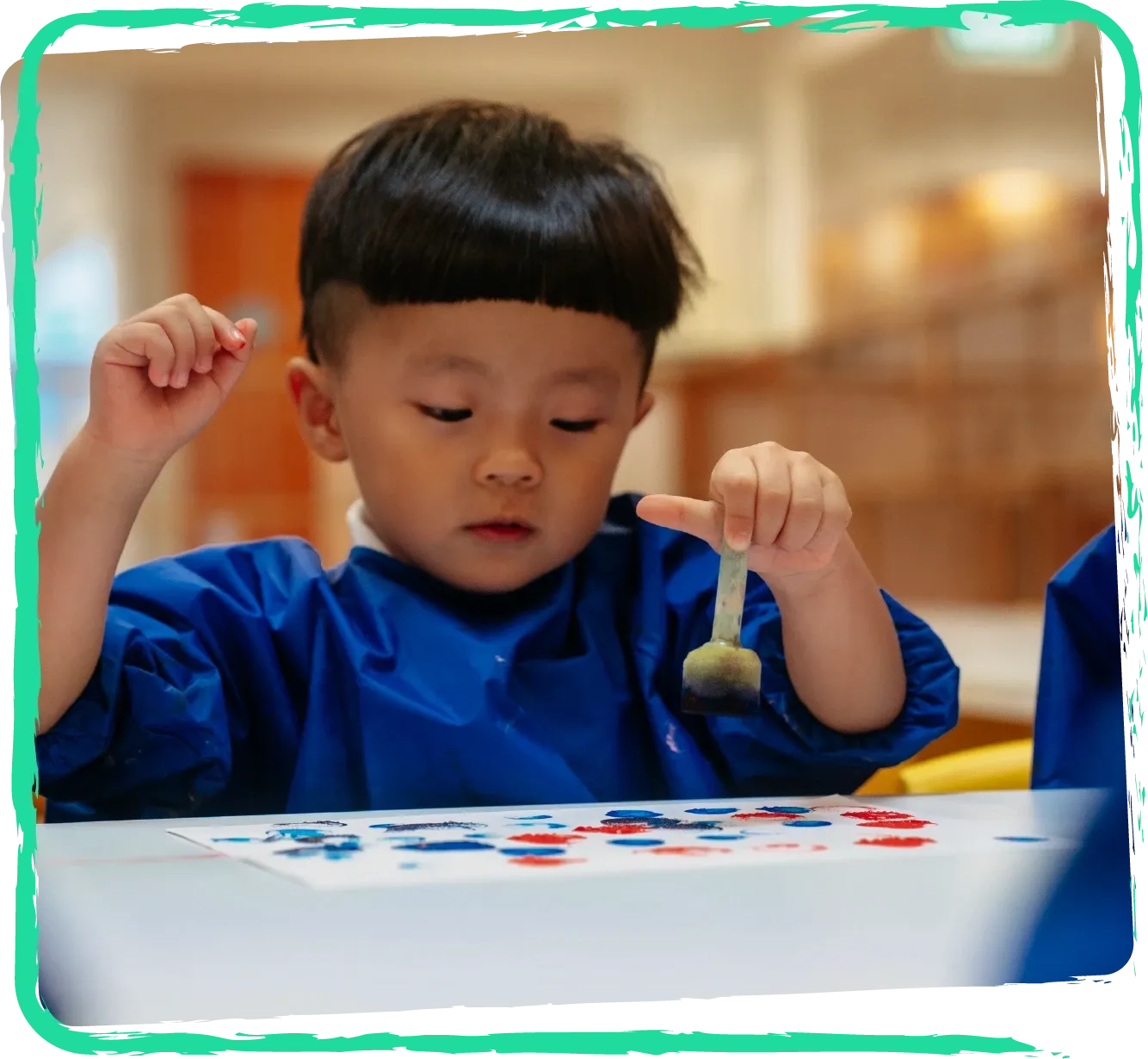 An infant exploring paint at a sensory table