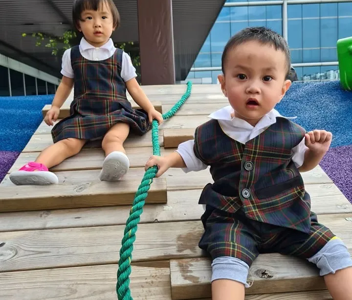 Toddler sitting on the outdoor play deck at Posso Preschool Jurong East