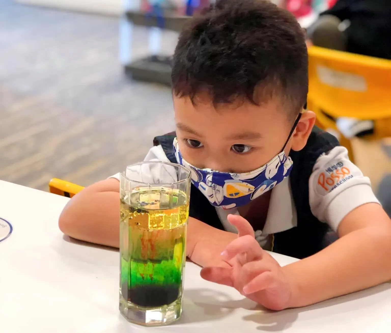 A boy watching a colourful science experiment