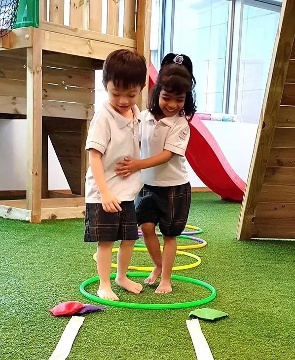 Two children holding hands at the playground